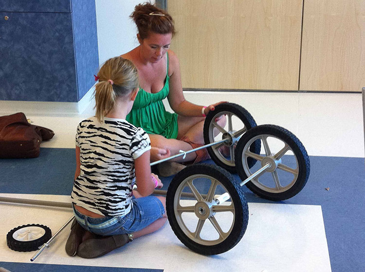 A mother and young daughter invent a vehicle using PVC pipe and wheels in Spark!Lab at the Terry Wells Nevada Discovery Museum