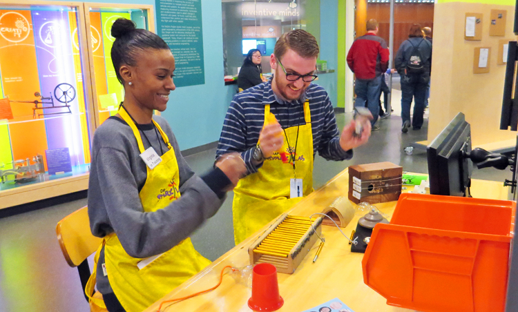 Two Spark!Lab volunteers smiling as they work on a project