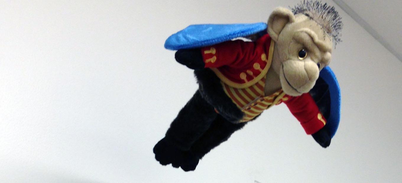 Flying monkey plush toy suspended from office ceiling